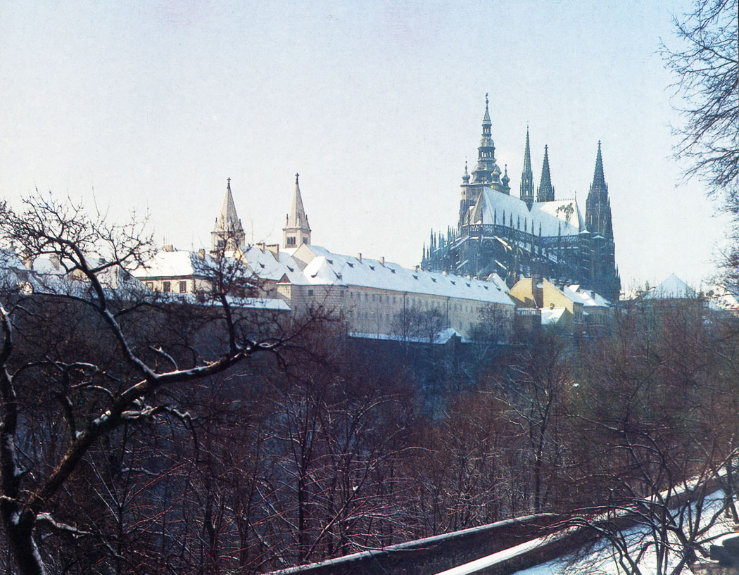 The view of the Castle from the Royal Gardens, separated from the Castle spur by the Stag Moat with the precints of the former St. George's Convent in the foreground. The Convent of the Benedictine nuns was founded in 973 A. D. and was the oldest convent in Bohemia. It was dissolved in 1782. Now it houses the collections of the National Gallery.