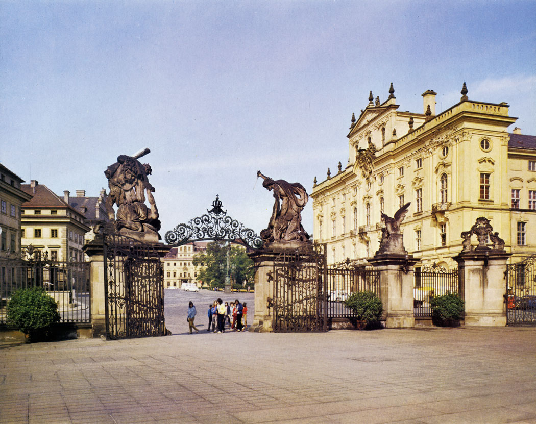 A view from the first courtyard of Prague Castle to Hradcany Square centres attention on the Archi-episcopal Palace on the northern side. The residence was built for the Archbishops after 1561, when the Prague Archbishopric was re-established. The original Renaissance building underwent several alterations in the course of the centuries: in Renaissance style in the years 1562 - 1564 and again in 1599, then it was restyled in Baroque in 1669 -1674 by Jean B. Mathey and in Rococo by J. J. Wirch in the years 1763 - 1764.